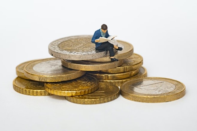 Image of a person sitting on a stack of coins to signify getting a return on your investment for your print marketing campaign.